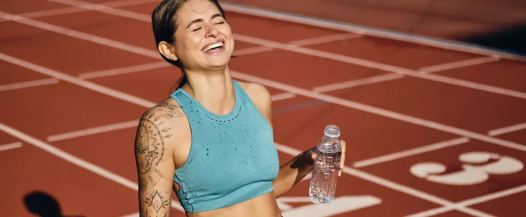 Atleta sorrindo após a corrida na pista. Fotografia esportiva Nexrise