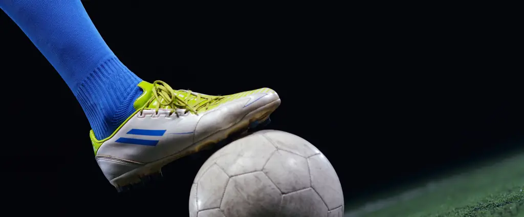 Chuteira sobre a bola de futebol. Fotografia esportiva Nexrise