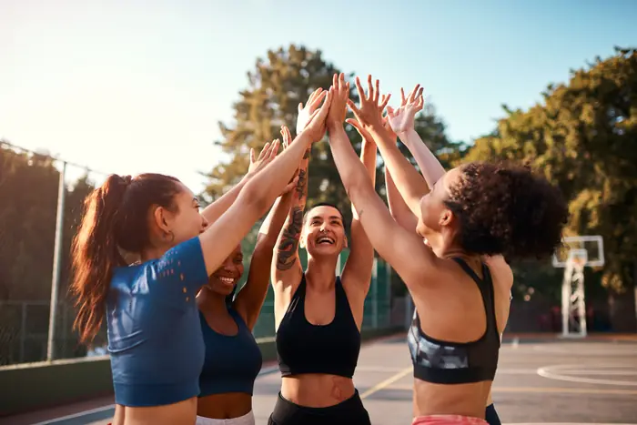 Equipe feminina comemorando unida na quadra